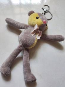 grey and yellow plush teddy bear keychain with a s