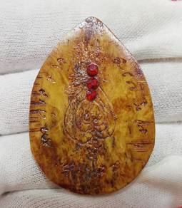 Antique amulet features intricate carvings and emb