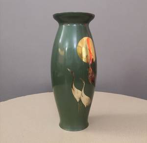 Green vase with sun and stork